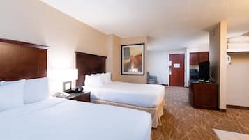 A hotel room with two beds, a desk, a chair, a TV, and a painting on the wall.