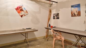 A room with a long table, a chair, and posters on the wall.