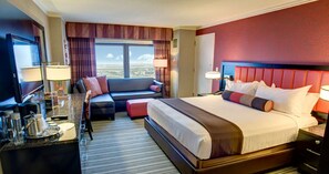 Relax in comfort with a large bed and seating area, featuring a sofa and flat-screen TV.