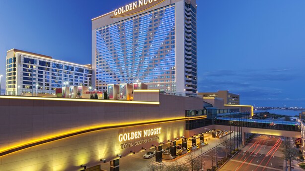 The exterior of the Golden Nugget Hotel with a prominent sign, modern architecture, and a view of the surrounding area. - Golden Nugget (Atlantic City)