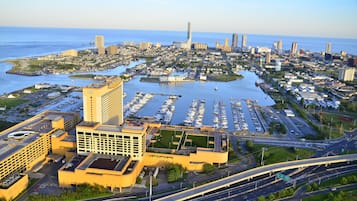 Un puerto deportivo con numerosos barcos, un gran edificio de hotel y un paisaje urbano con rascacielos al fondo.