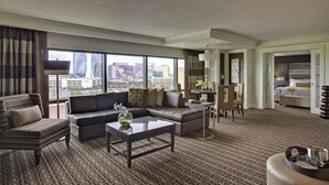 A modern hotel room with a large window, a sofa, a coffee table, and a dining area. - Golden Nugget (Atlantic City)