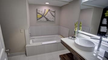 Ein modernes Badezimmer mit einer Badewanne, einem großen Spiegel und einem Waschbecken.