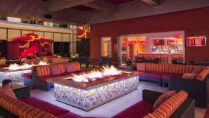 A modern lounge area with a fire feature, seating, and a bar area. - Golden Nugget (Atlantic City)