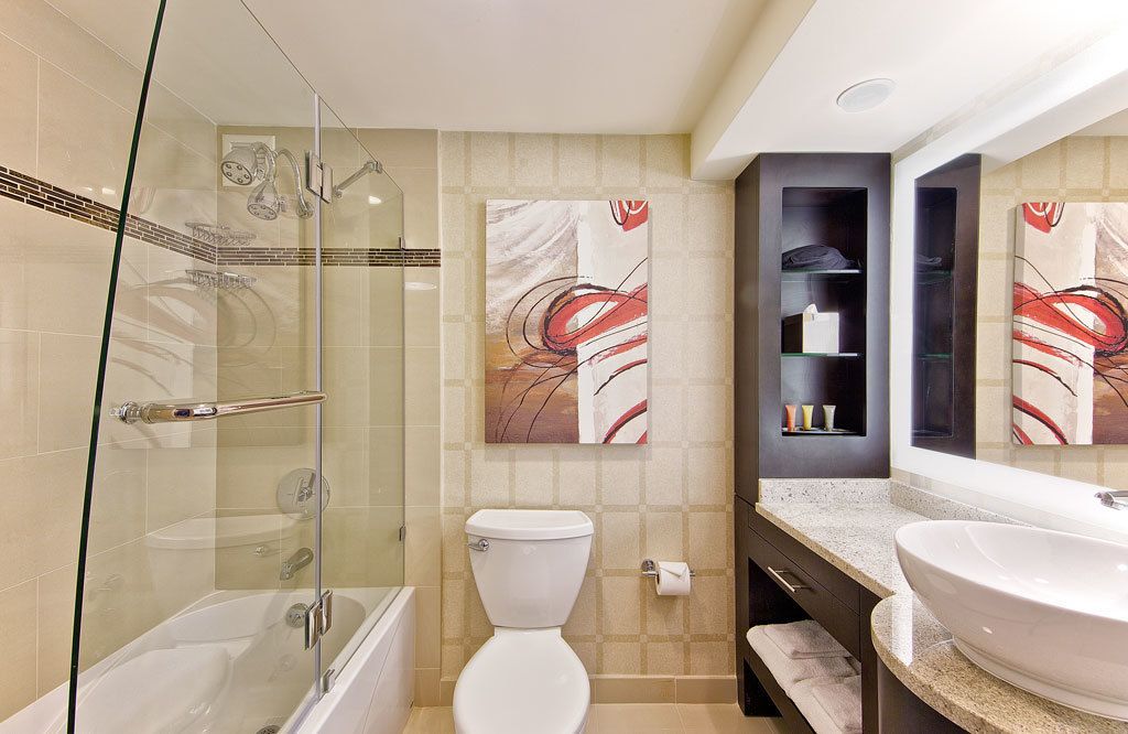 A modern bathroom with a glass-enclosed shower, a white toilet, and a large vanity with a double sink.