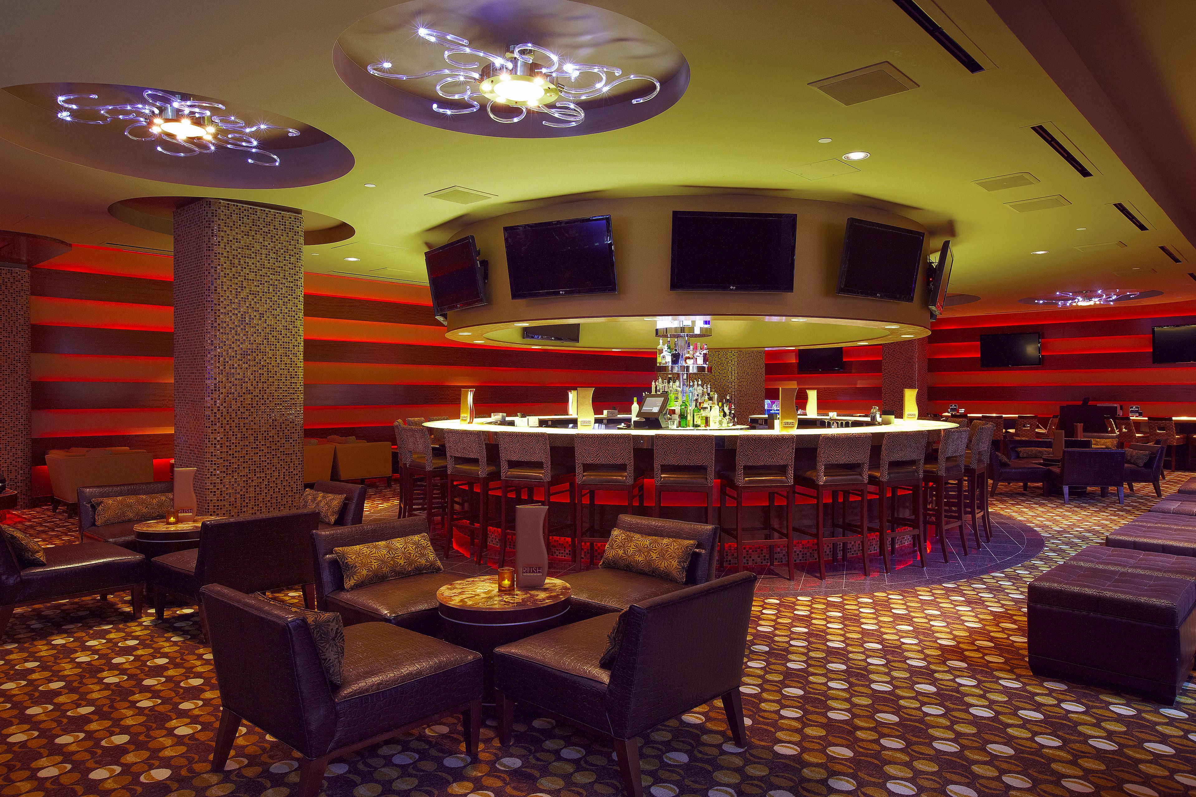 A bar area with a circular bar, multiple seating arrangements, and a patterned floor.