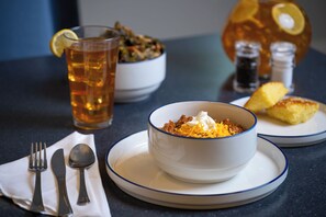 Una mesa con un plato de comida, una taza de té y un salero y pimentero.