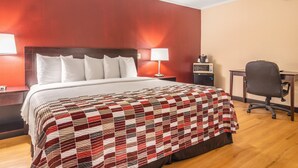 A hotel room with a large bed, a desk, and a chair. - Red Roof Inn Ashtabula - Austinburg (Austinburg)