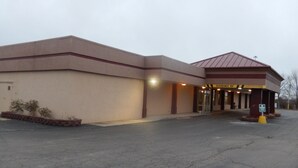 A building with a flat roof and a sign indicating 'CLEARANCE 84' for vehicle access. - Red Roof Inn Ashtabula - Austinburg (Austinburg)
