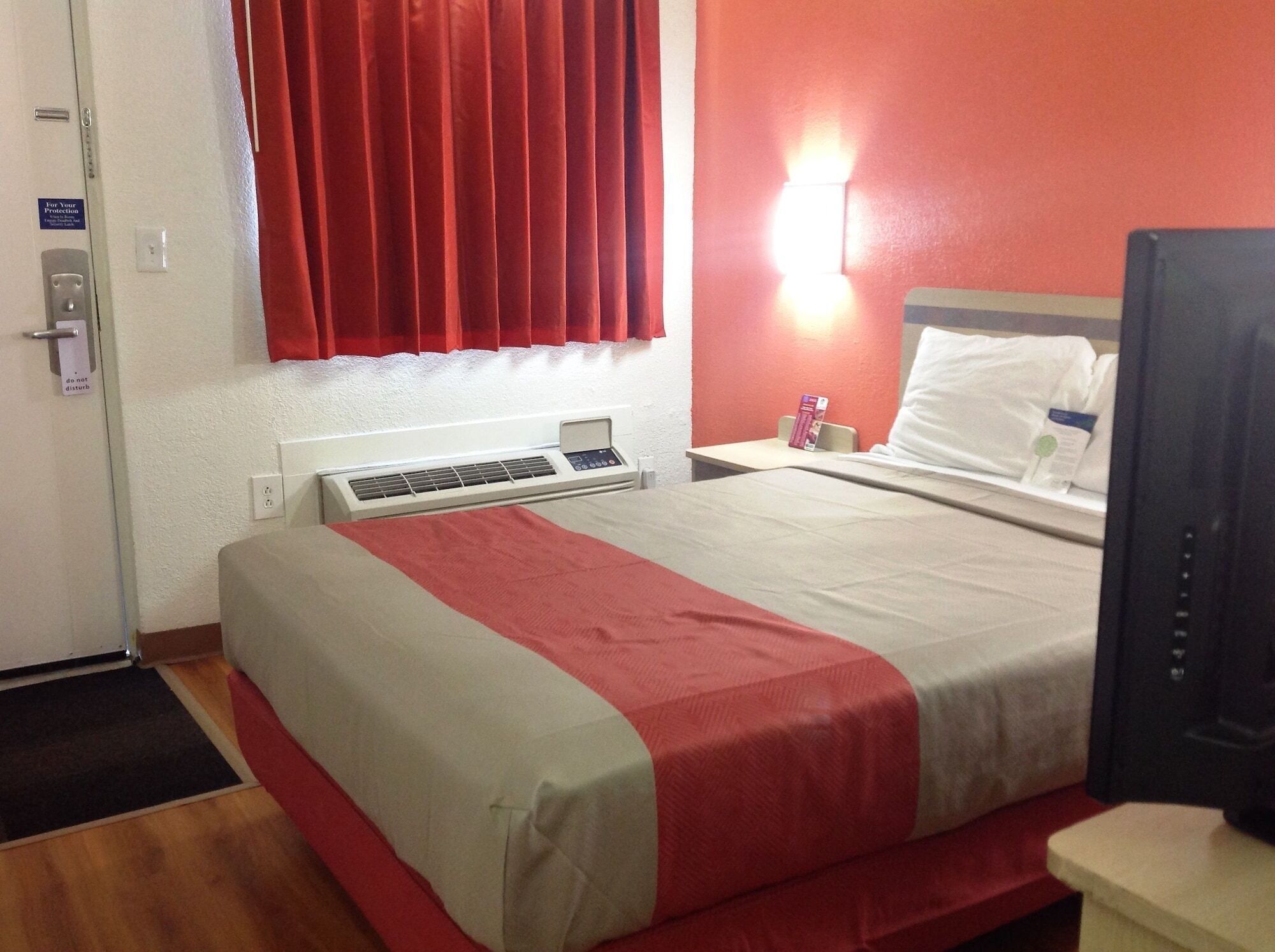 Une chambre d’hôtel équipée d’un lit, d’un bureau, d’un ordinateur et d’une télévision.