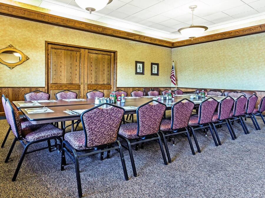 A conference room with a long table, chairs, and a flag.