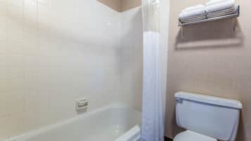 Un baño con bañera, inodoro y toallero.