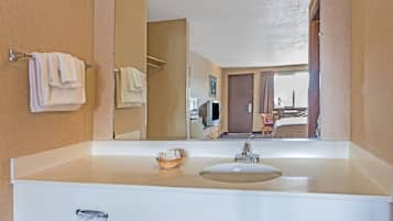 Un baño de hotel con un espejo grande, un lavabo y un perchero para toallas.