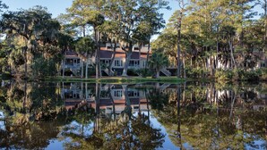A house with a reflection in the water, surrounded by trees and a small pond. - Club Wyndham Ocean Ridge (Edisto Island)