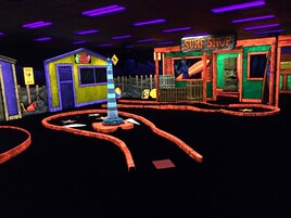 A brightly lit indoor amusement area with a surf shop and a turtle-themed ice cream stand.