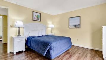 A bedroom with a bed, two bedside tables, and two wall-mounted lamps.