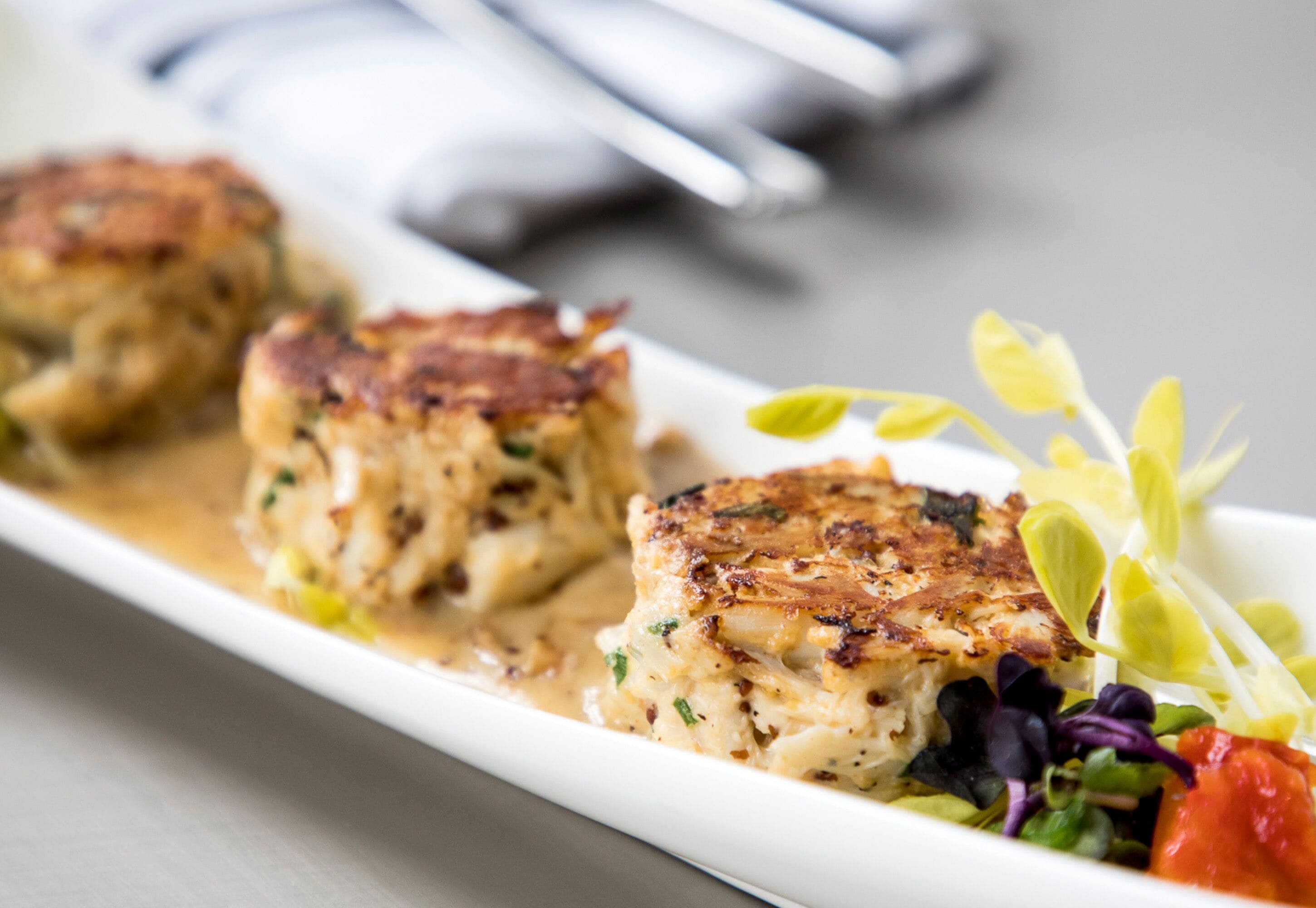 A plate of food with crab cakes and a side salad.