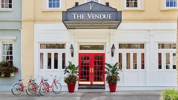 Experience the classic charm of The Vendue, where a red door and black awning welcome you to a tranquil atmosphere.