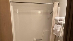 Un baño con bañera, inodoro y toallero con toallas.