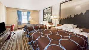 Quarto de hotel com duas camas, uma mesa, uma televisão e uma janela com cortinas.