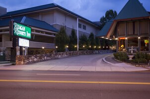 A hotel entrance with a sign for Reagan Resorts Inn, a stone wall, and a landscaped area with a fountain.
