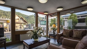 A hotel lobby with a large window offering a view of a mountain and a sign for Reagan Resorts. - Reagan Resorts Inn (Gatlinburg)