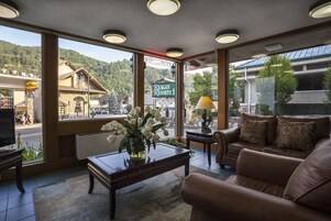 A hotel lobby with a large window offering a view of a mountain and a sign for Reagan Resorts.