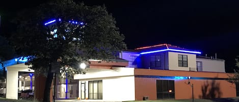 Vista frontal de la propiedad por la tarde o noche