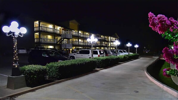 Un hôtel à plusieurs étages, doté d’un parking et d’un éclairage extérieur adéquat.