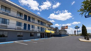 Um motel com um estacionamento, um letreiro da Days Inn e um letreiro do Walmart ao fundo.