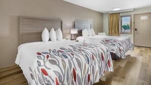 Une chambre d’hôtel avec deux lits, un téléviseur à écran plat, une fenêtre avec des rideaux et une porte avec une serrure.