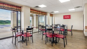 Une salle de conférence équipée de tables et de chaises, dotée de grandes fenêtres et d’un panneau indiquant que le Wi-Fi est disponible gratuitement.
