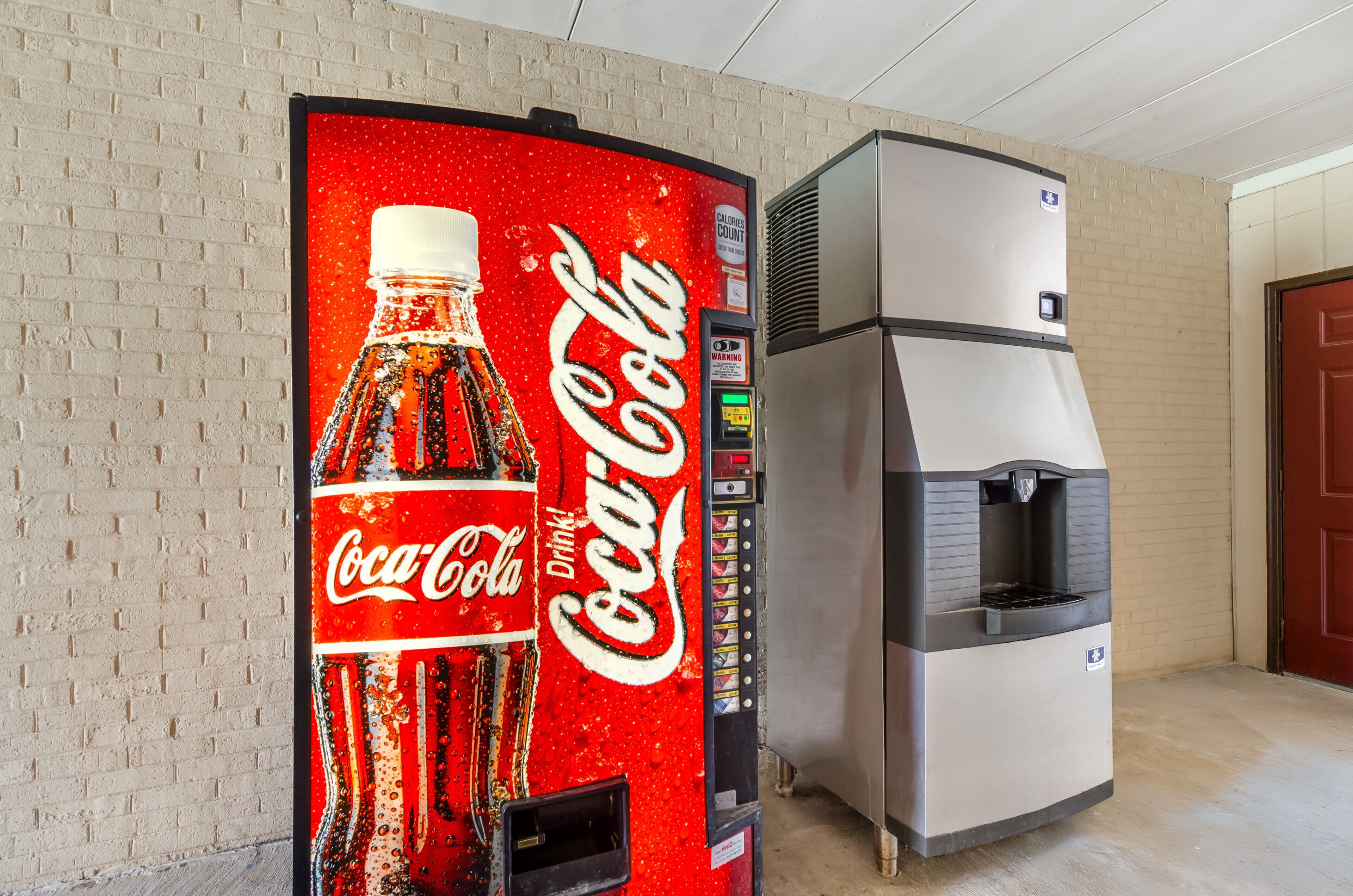 A vending machine with a Coca-Cola logo and a water dispenser.