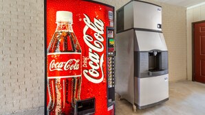 Un distributeur automatique orné du logo Coca-Cola et muni d’un distributeur d’eau.