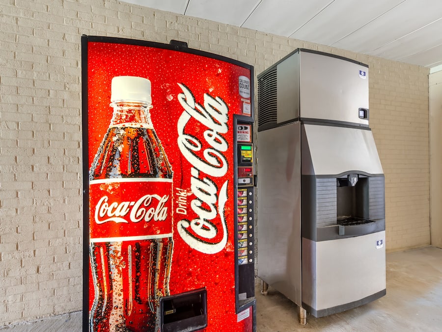 A vending machine with a Coca-Cola logo and a water dispenser.