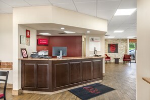 A reception area with a desk, a flat-screen TV, and a sign indicating free Wi-Fi. - Red Roof Inn Staunton (Staunton)