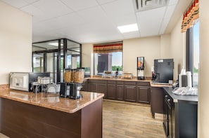 A modern kitchen with granite countertops, a coffee station, and a view of the outdoors. - Red Roof Inn Staunton (Staunton)