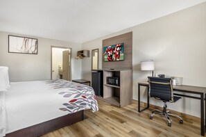 A hotel room with a bed, a desk, a chair, a TV, a microwave, and a wardrobe. - Red Roof Inn Staunton (Staunton)