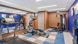 A gym with cardio equipment, a mirrored wall, and a checkered floor. - Comfort Inn Monticello (Charlottesville)