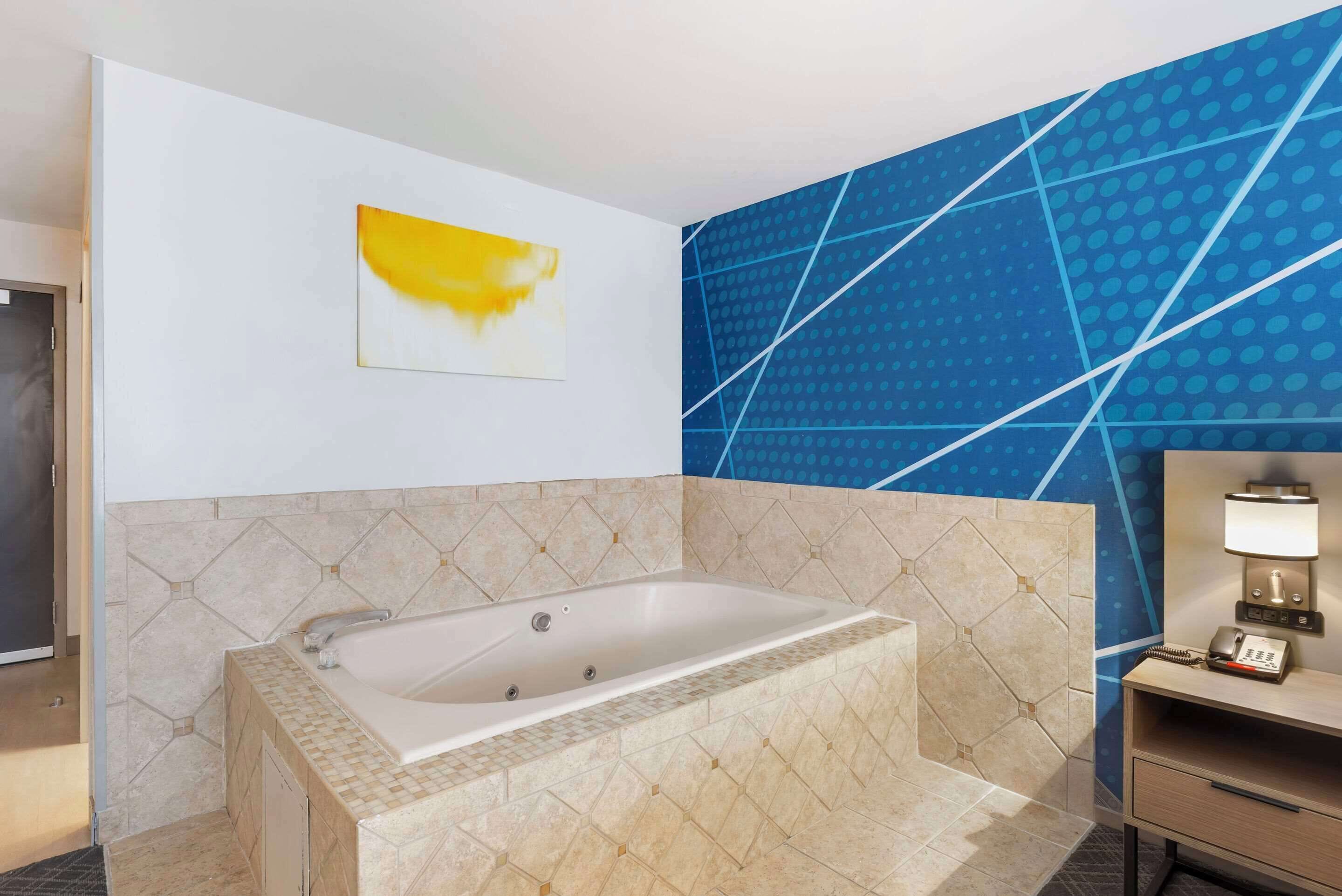 Une salle de bain moderne avec une baignoire sur pieds, un porte-serviettes et un téléphone fixé au mur.