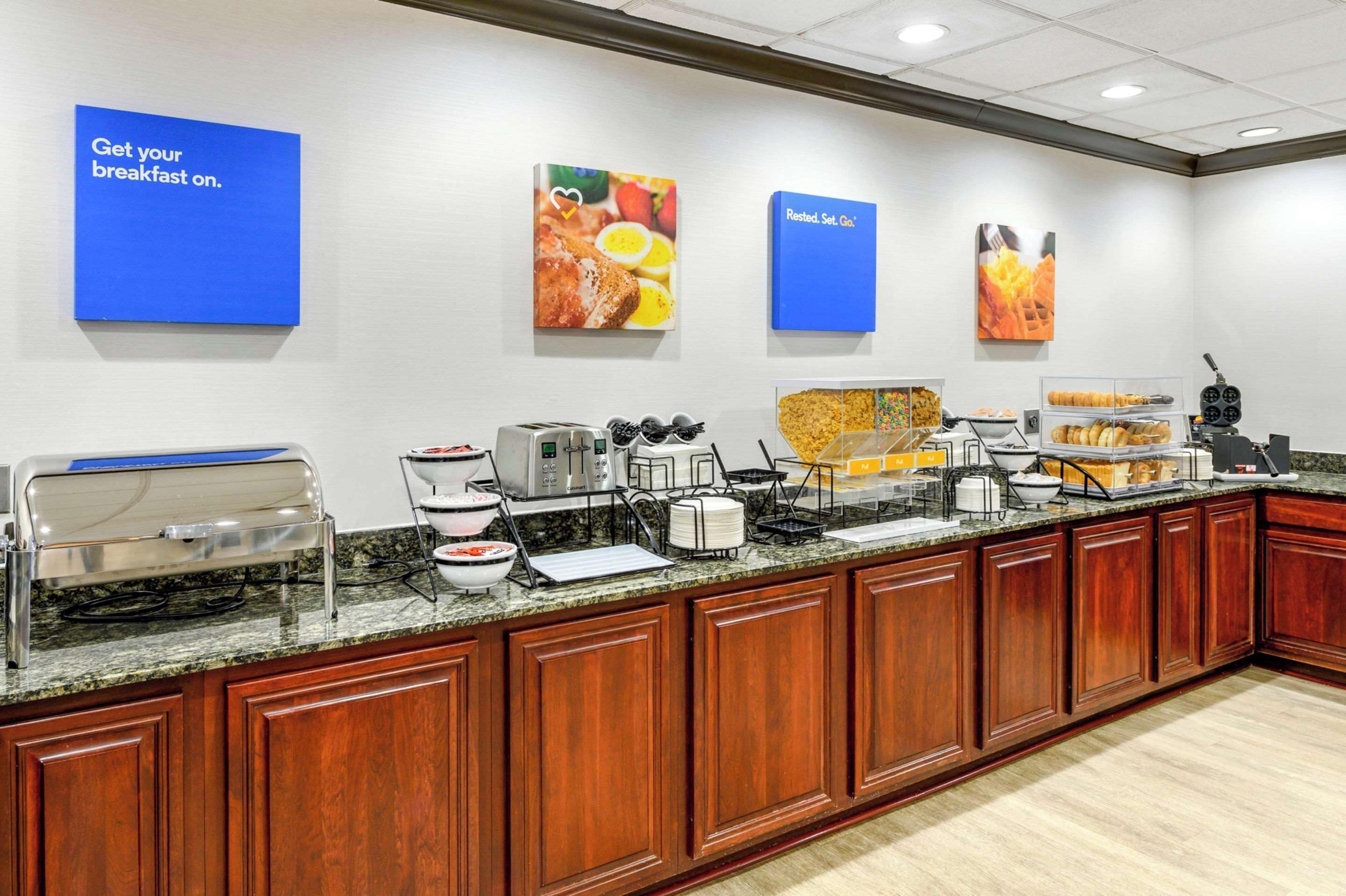 A breakfast bar with a variety of food options and a coffee station.