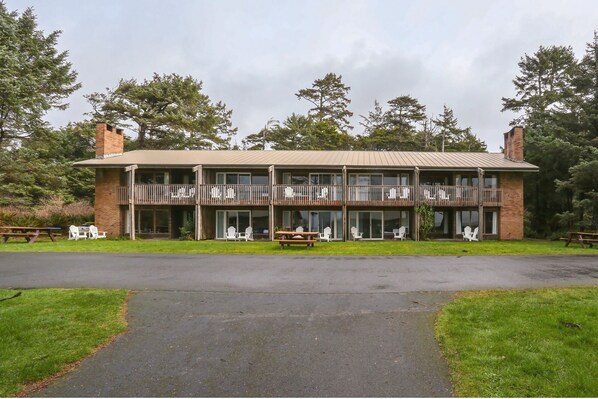 A two-story building with a flat roof, large windows, and a covered porch with chairs. - Kalaloch Lodge (Forks)