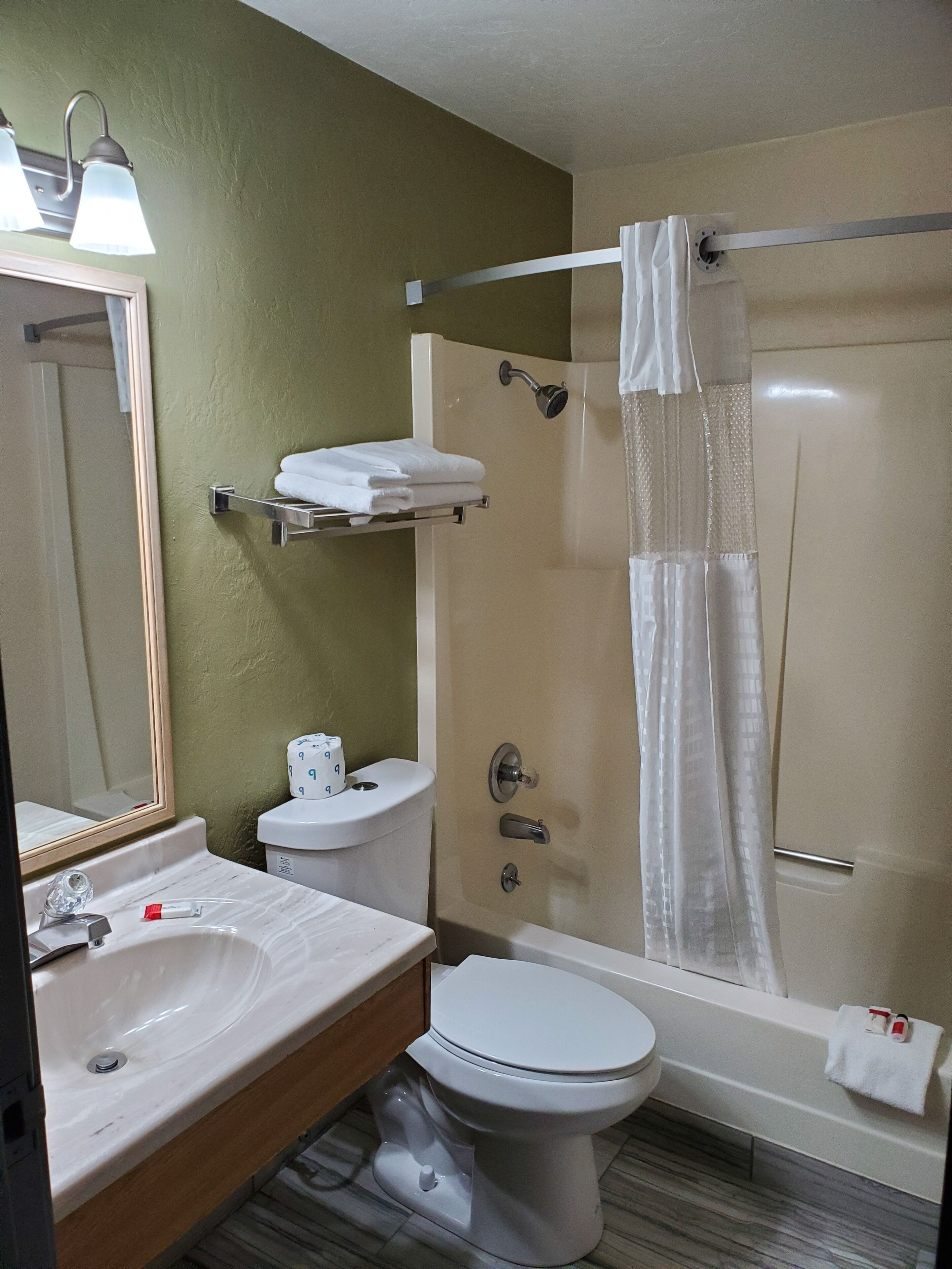 Un baño con inodoro, lavamanos y ducha.