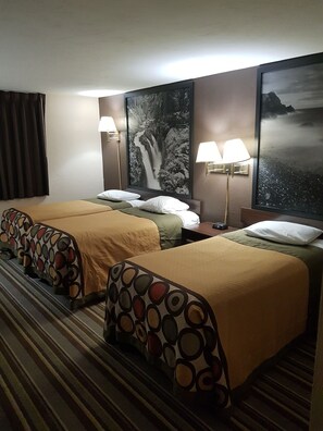 A hotel room with two beds, each with a patterned headboard, a large waterfall painting on the wall, and two wall-mounted lamps. - Super 8 by Wyndham Shelton (Shelton)