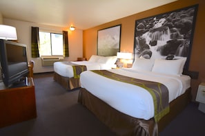 Habitación de hotel con dos camas, televisor, ventana grande con cortinas y un cuadro de una cascada en la pared.