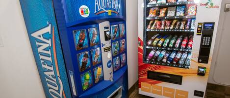 Two vending machines, one labeled AQUAFINA and the other with various snacks and drinks.