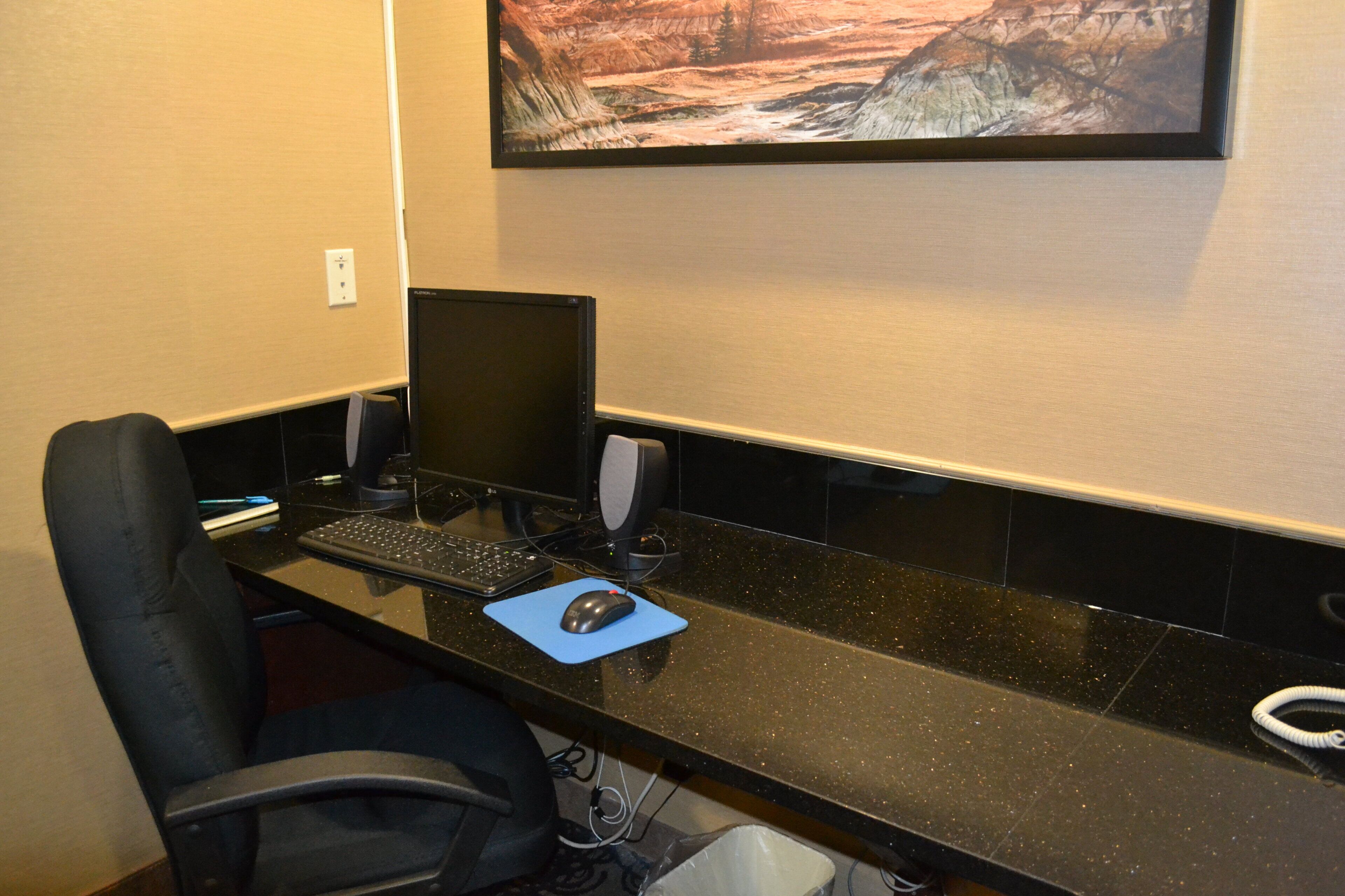 Un espacio de trabajo con computadora de escritorio, una laptop, un monitor, teclado, ratón y silla.