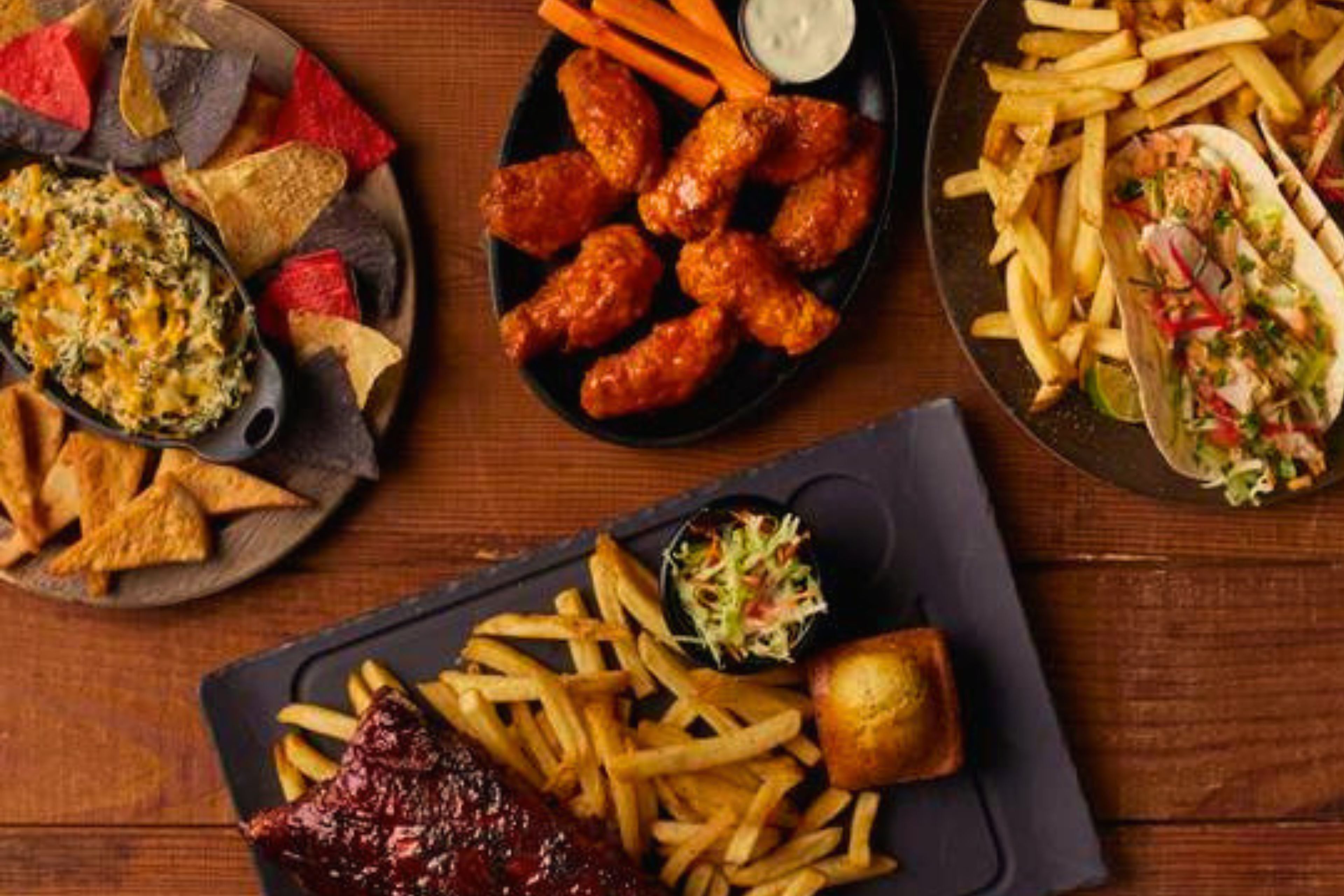 A variety of food items including wings, fries, and a salad.