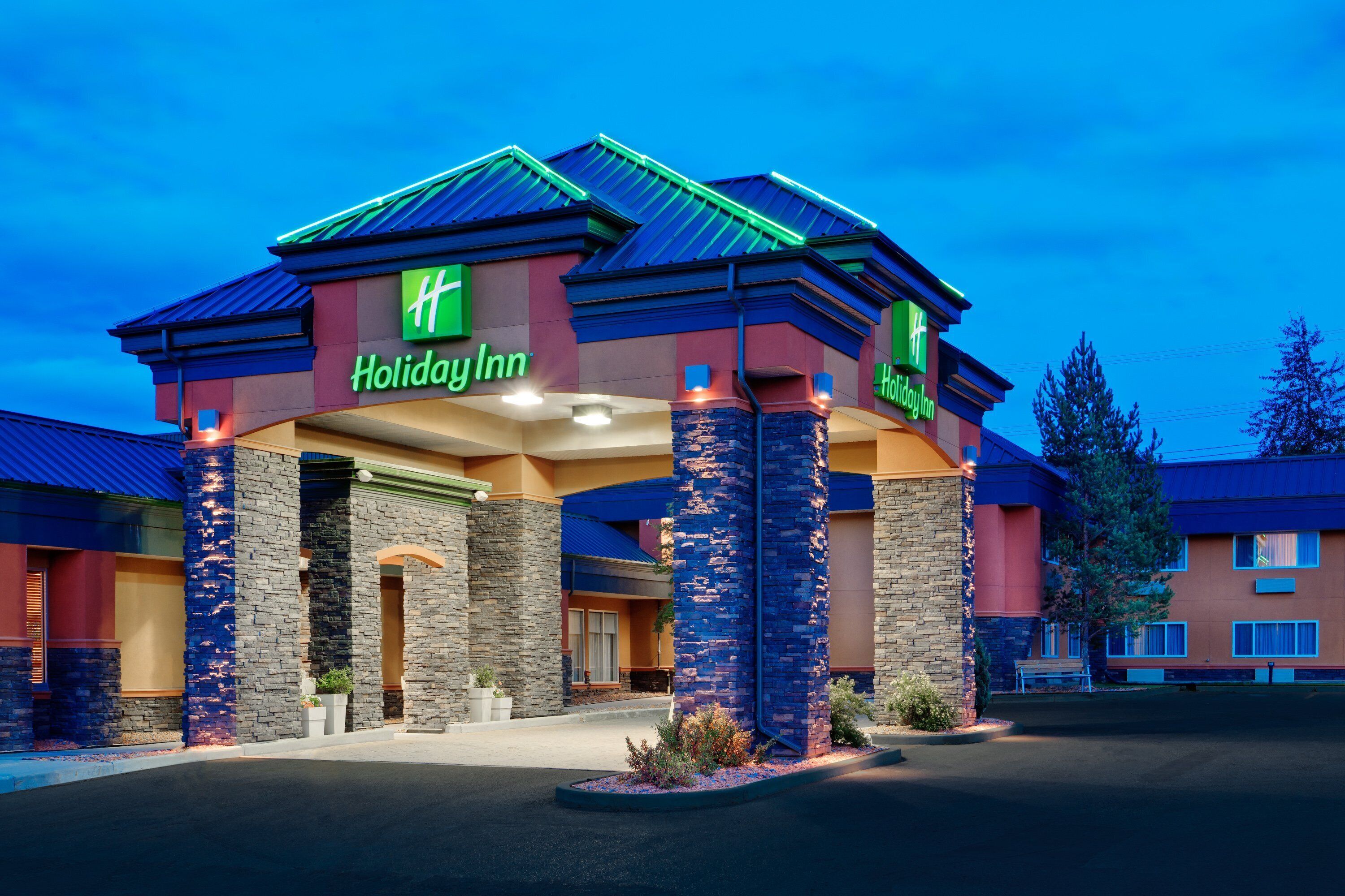A Holiday Inn hotel with a distinctive architectural style, featuring a prominent entrance with a covered walkway and stone pillars.