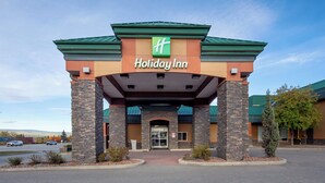 The exterior of a Holiday Inn hotel with a green roof, stone pillars, and a clear sky. - Holiday Inn Hinton by IHG (Hinton)